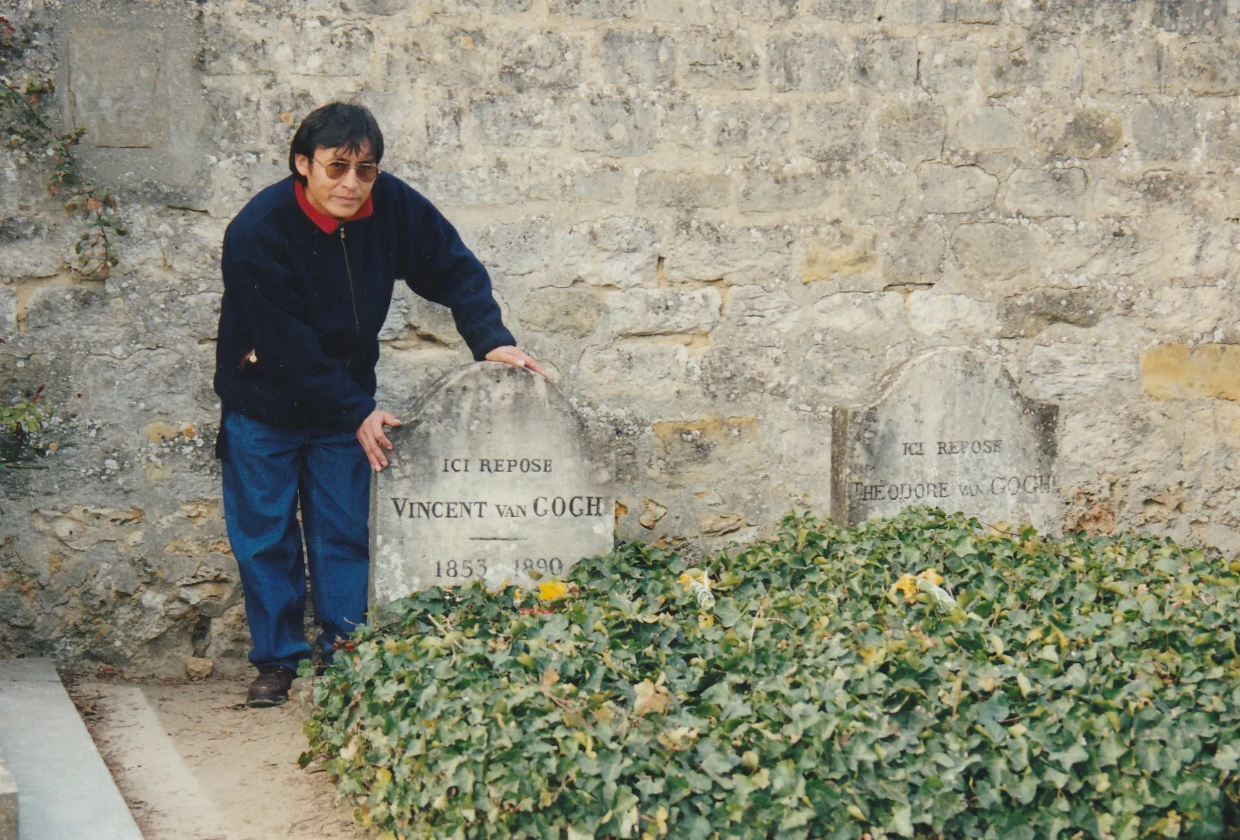 Alejandro Galindo junto a las lápidas de Vincent y Theo van Gogh, cubiertas de hiedra