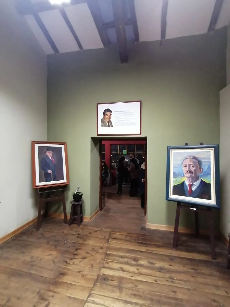 Dos retratos sobre caballetes a la entrada de la sala