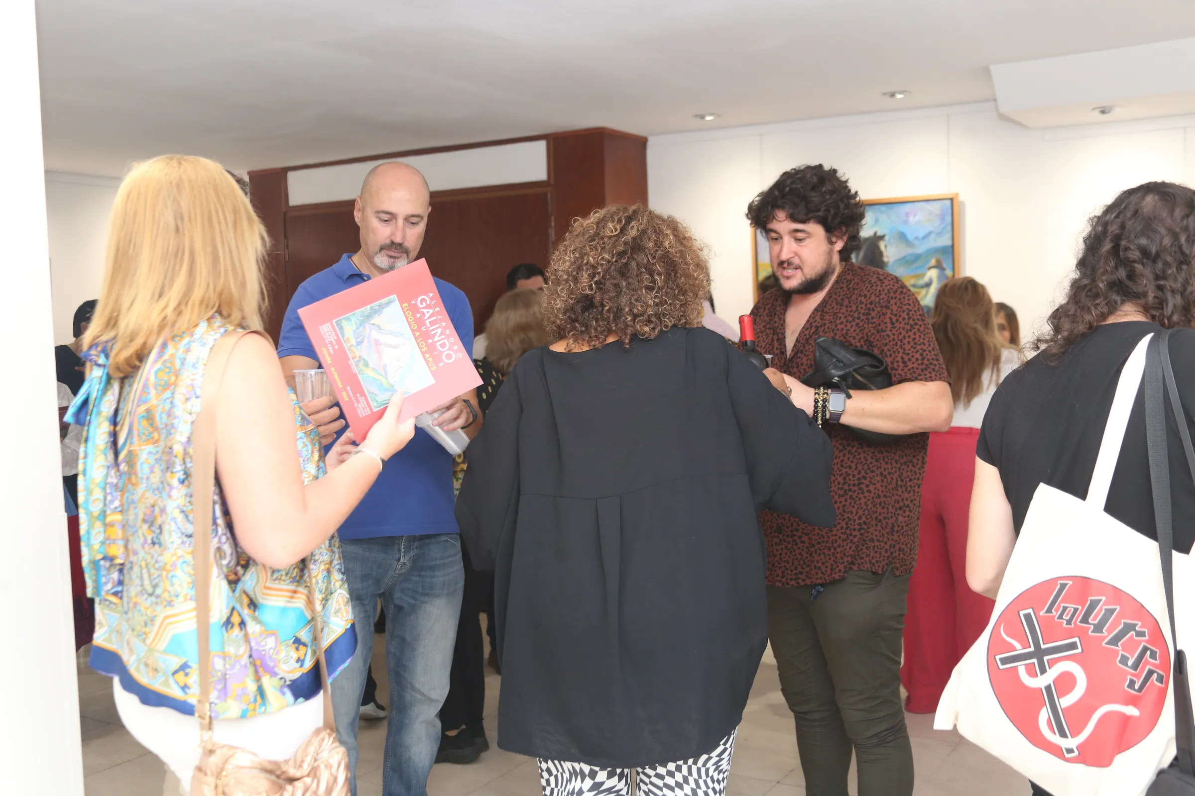 Asistentes conversan con el catálogo en la mano