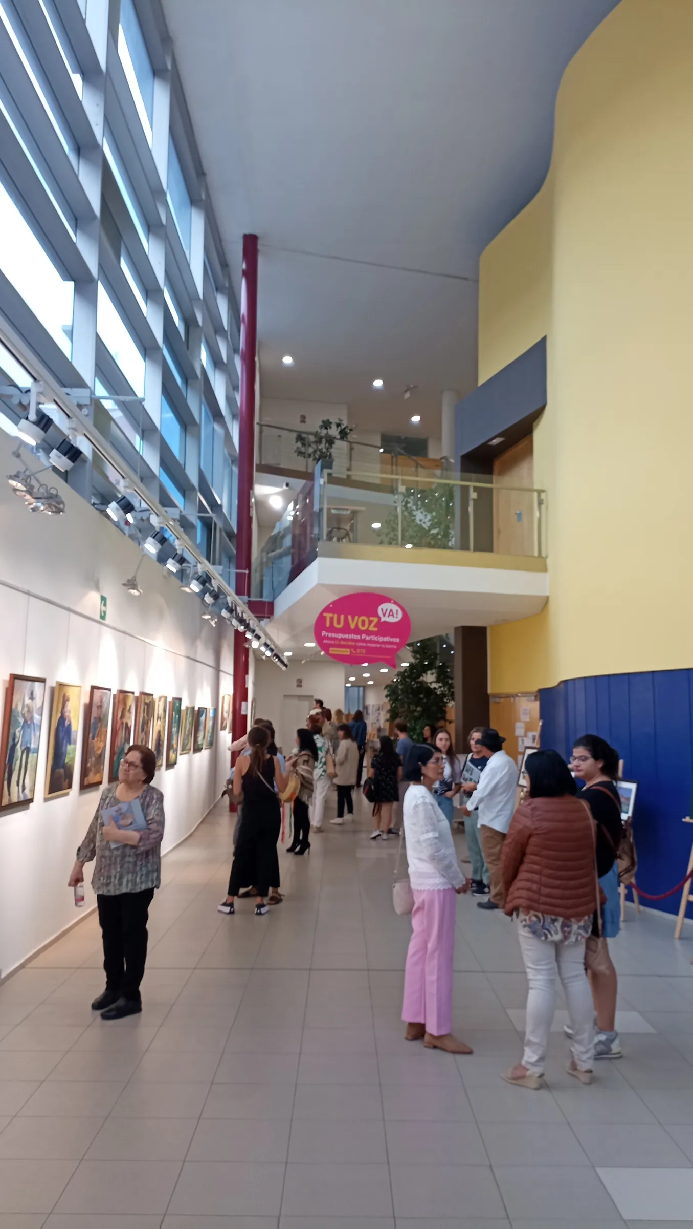 La galería del Centro Cívico con los cuadros colgados y el público
