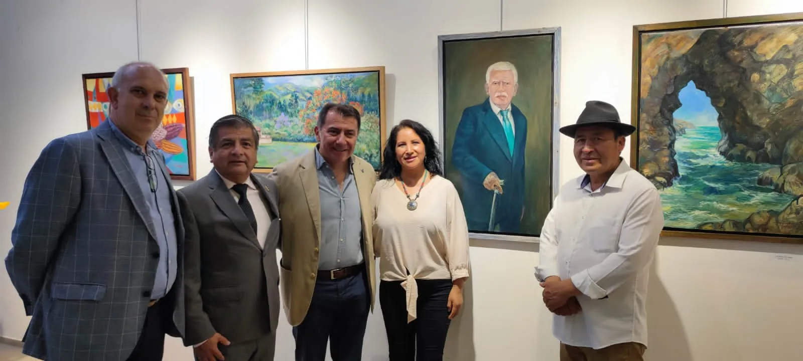 Alejandro Galindo con cinco asistentes ante los cuadros