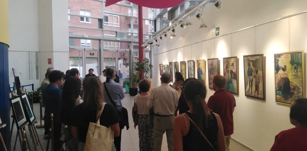 Visitantes ante los cuadros de la sala