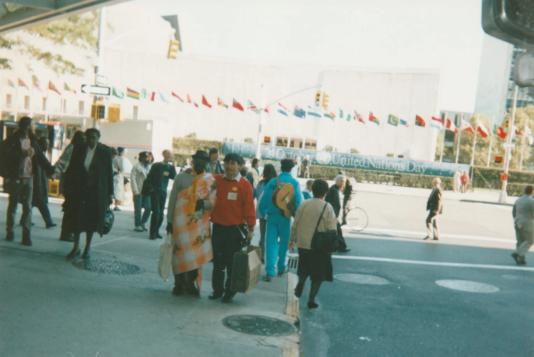 Alejandro Galindo cruza la calle frente a la sede de la ONU, con las banderas de los países y una pancarta que dice «24 October United Nations Day»